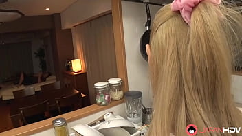 A Japanese homemaker gives a blowjob in the kitchen without censorship